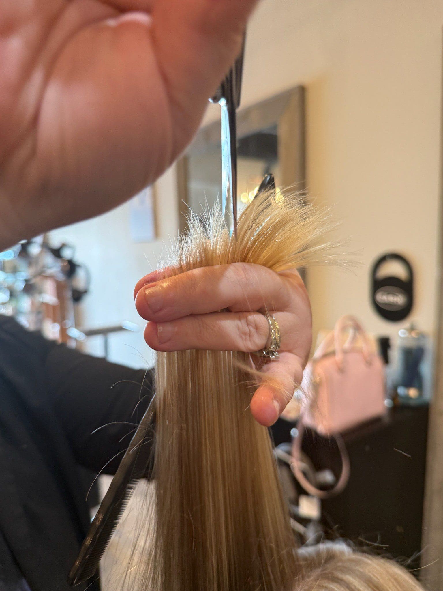 Scissors trimming long blonde hair with comb