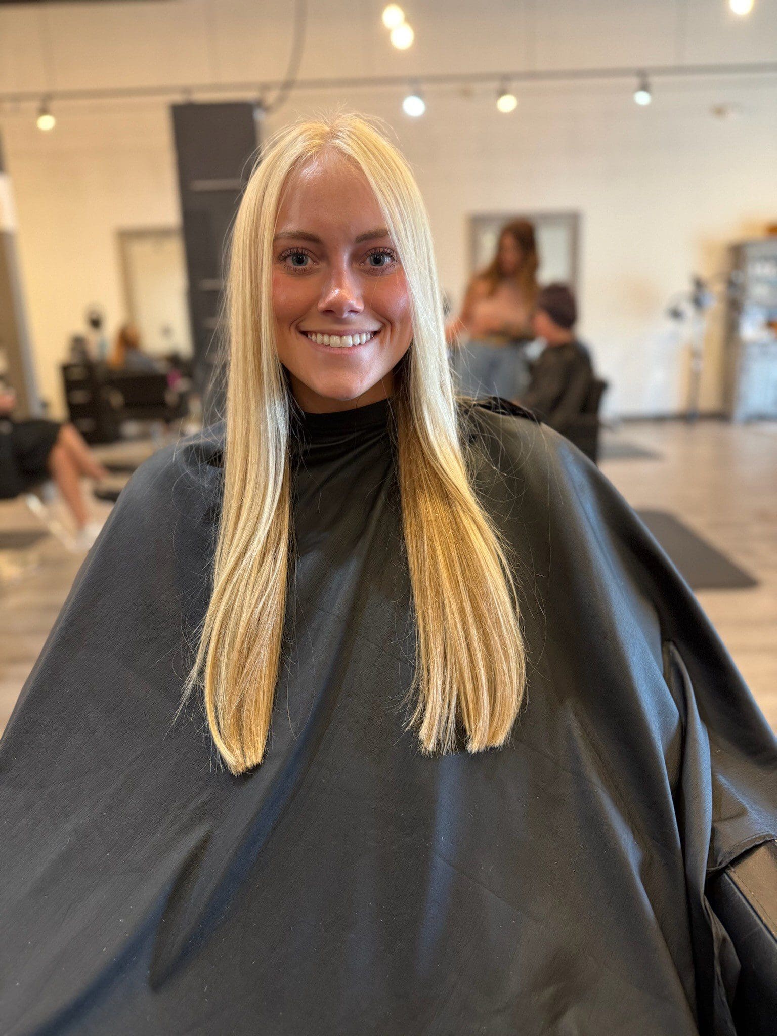 Smiling blonde woman in hair salon