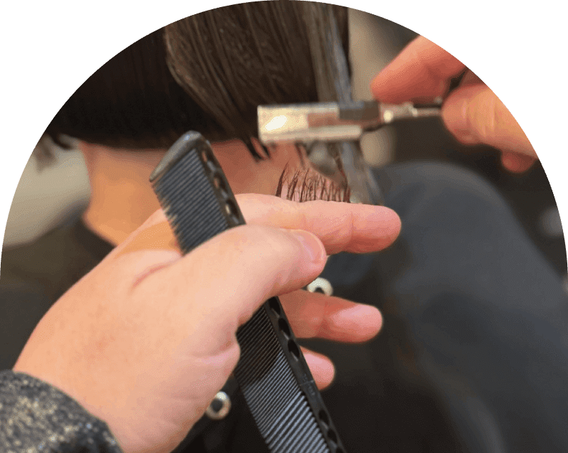 Hairdresser cutting bangs with scissors and comb