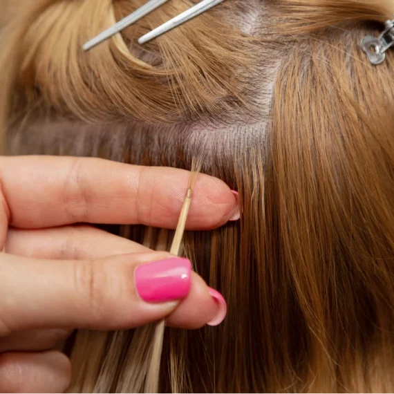 Stylist applying hair extensions